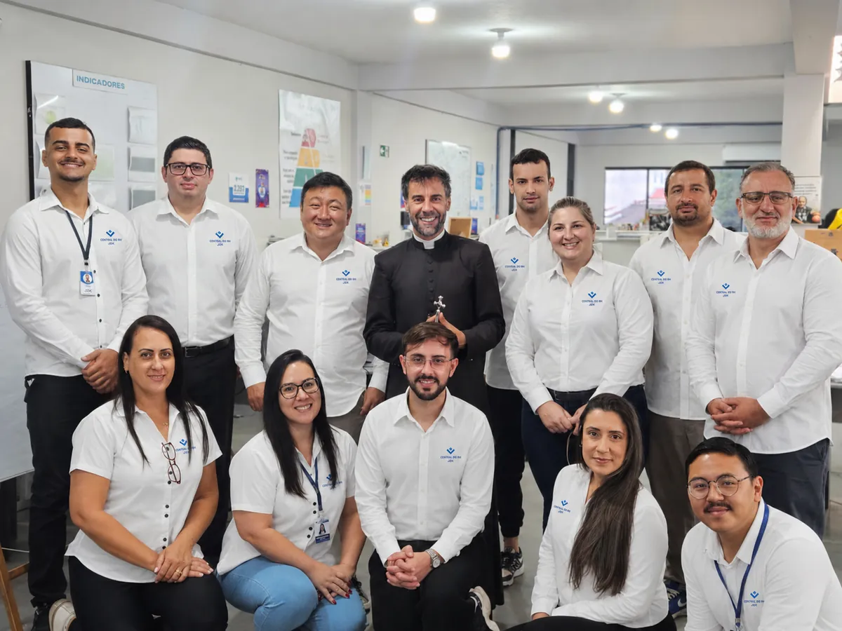 Equipe da Central do RH reunida no escritório, de camisa com a marca